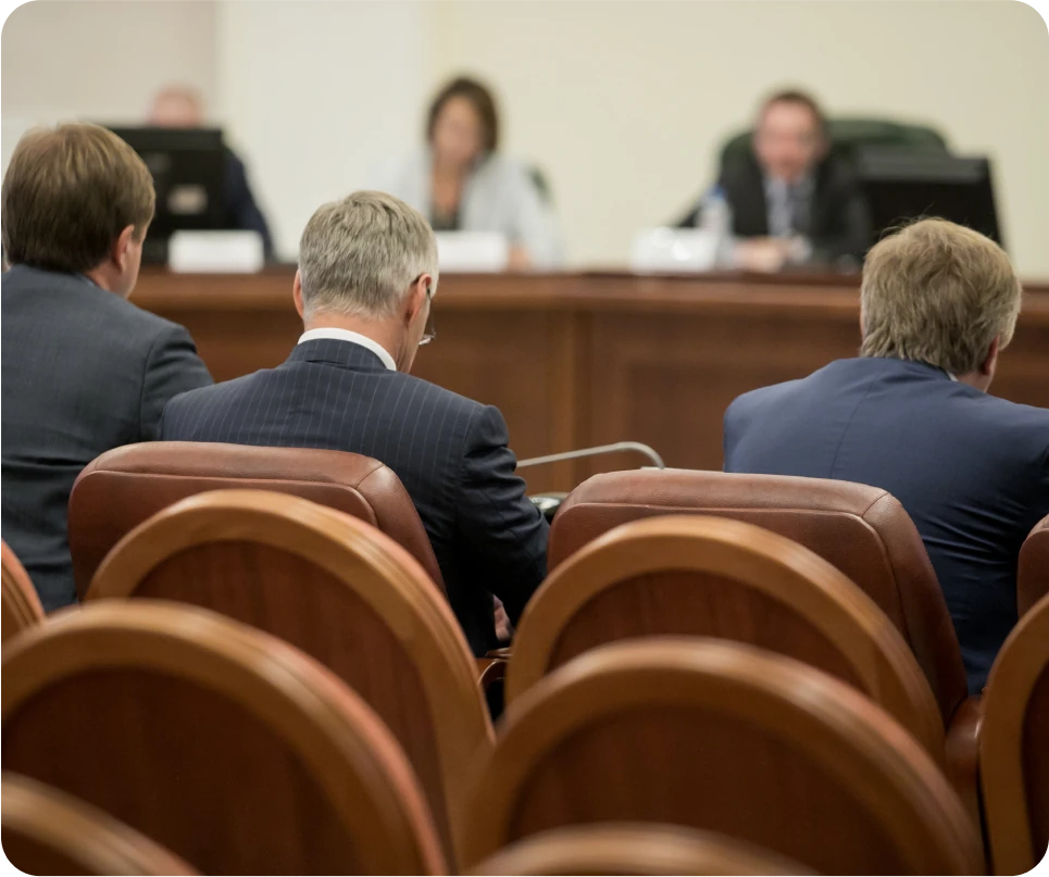 A group of people sitting in chairs in a government building.