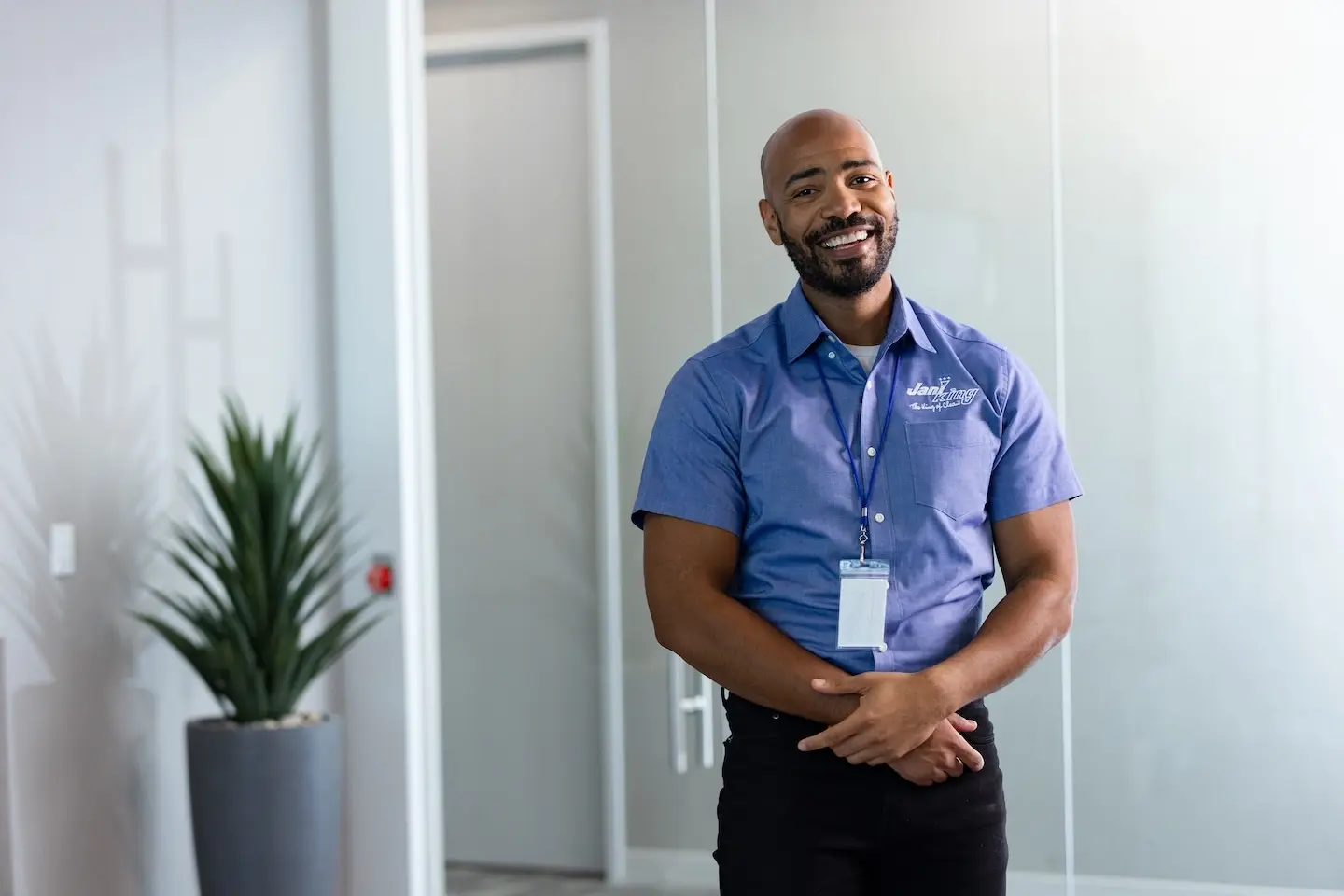 Jani King franchise owner stands in meeting room with arms crossed over waist.